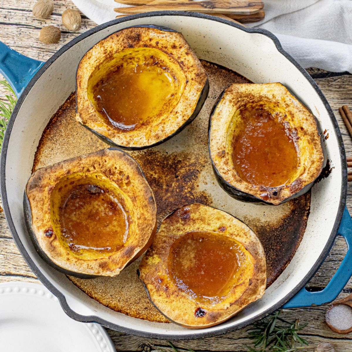 acorn squash halves in a cast iron pan