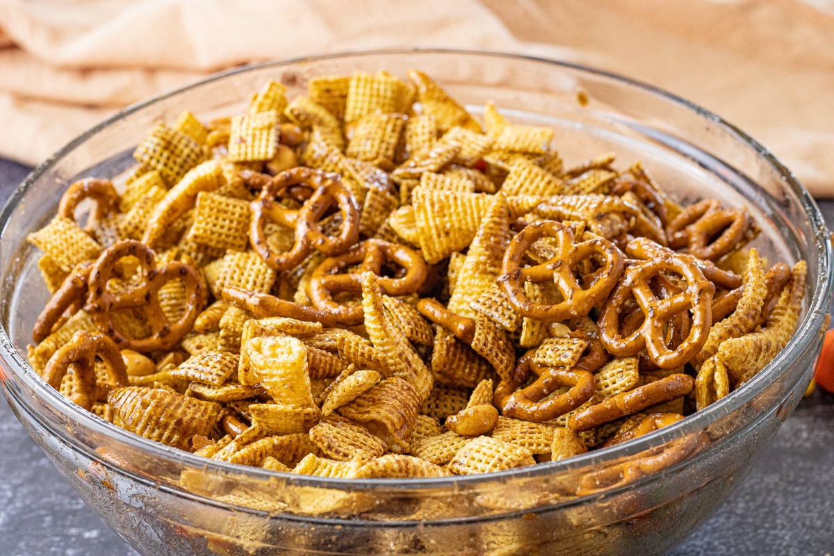 pretzel, cereal, bugles and nuts in a glass mixing bowl