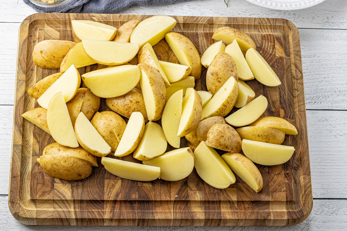 sliced golden potatoes on a wooden cutting board