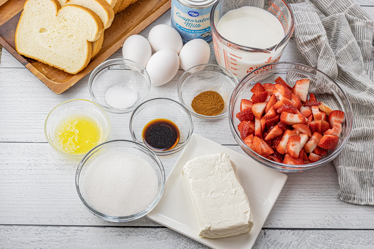 bowls of milk, sugar, cinnamon, vanilla, melted butter, sliced strawberries