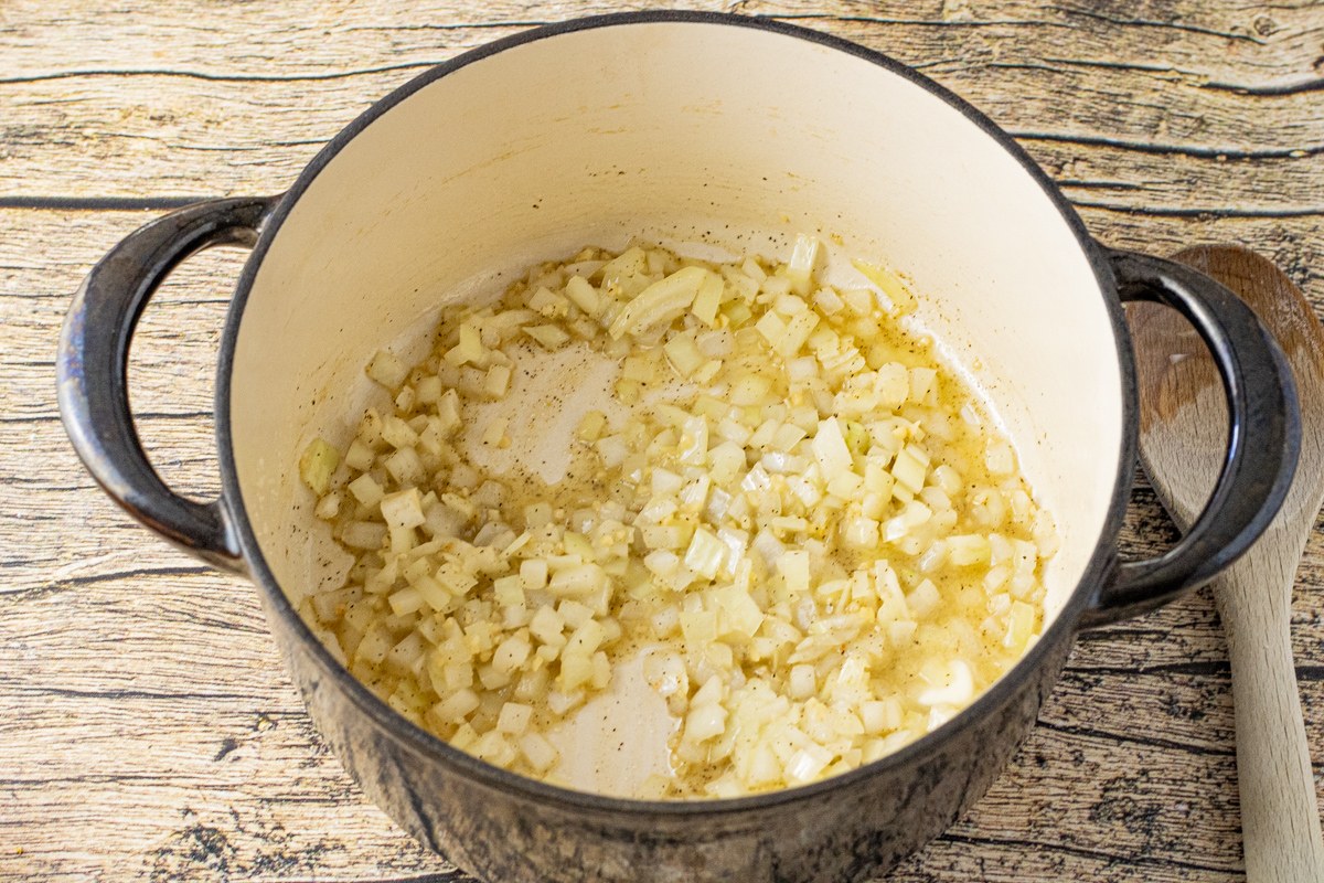 onions and garlic in the bottom of a enameled dutch oven pot