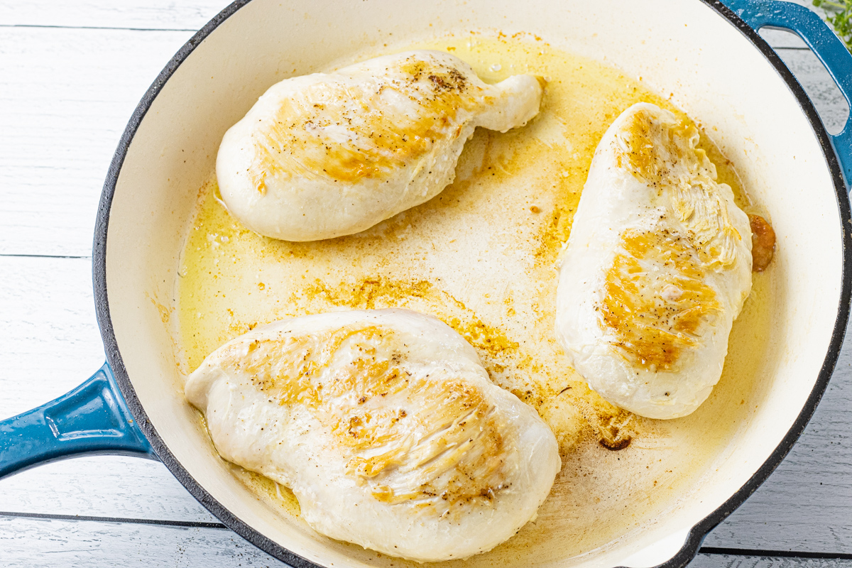 3 chicken breasts browned in a cast iron enameled skillet