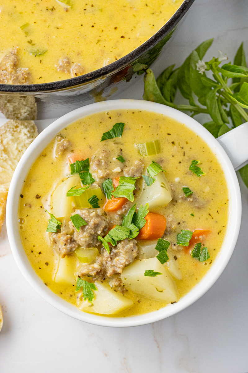 close up of sausage potato soup in a white bowl
