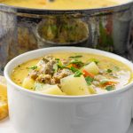 white bowl with sausage potato soup inside