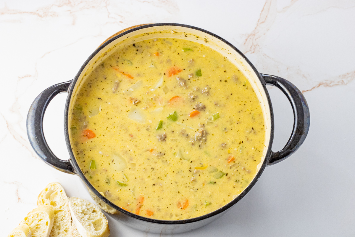 creamy sausage potato soup in a large black dutch oven pot