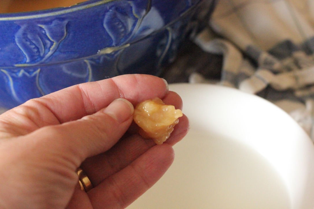 hand holding a piece of caramel