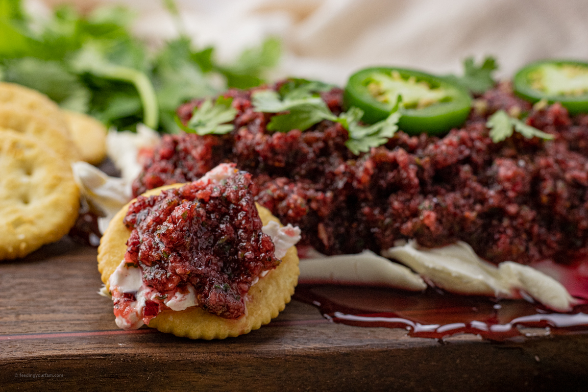 cracker topped with cream cheese and cranberry salsa
