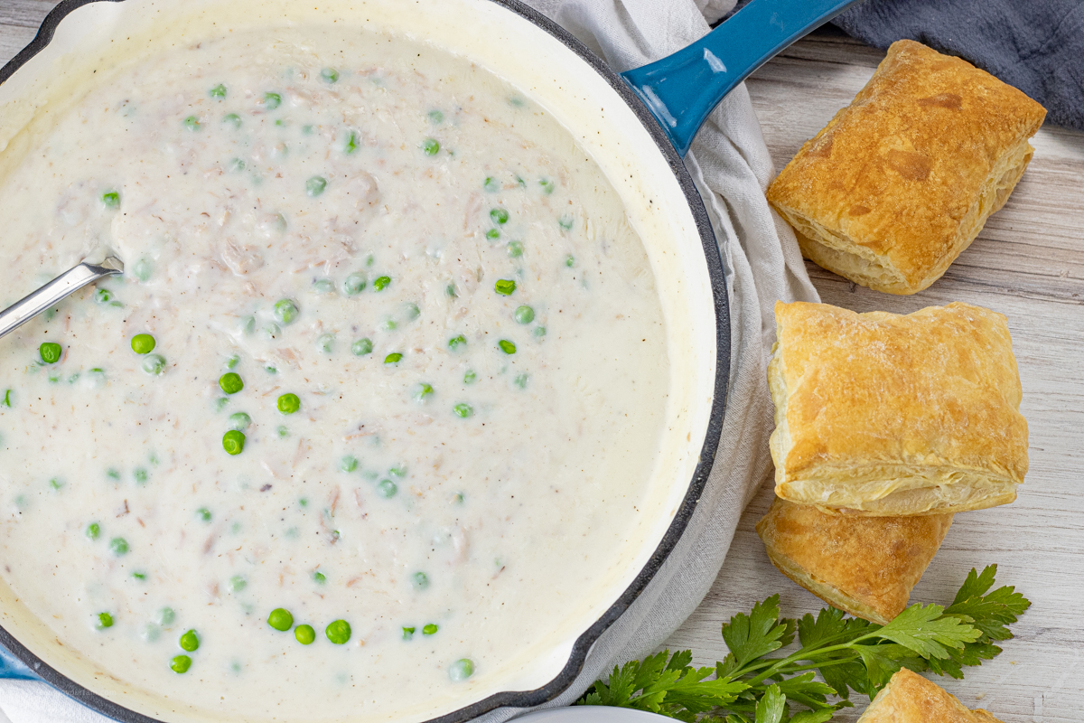 big skillet of creamy white sauce tuna with green peas