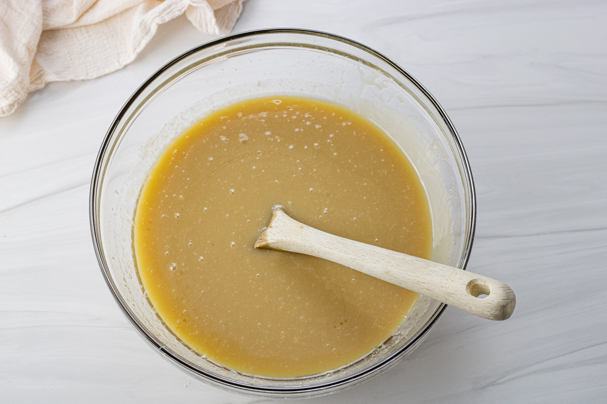 bowl of ingredients to make caramels with a wooden spoon