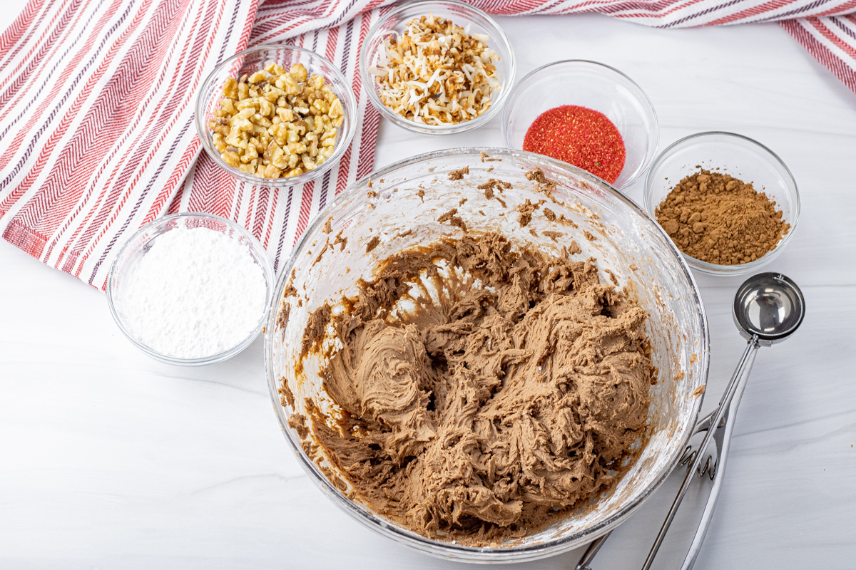 glass bowl of truffle batter surrounded by small bowls to dip the truffles into