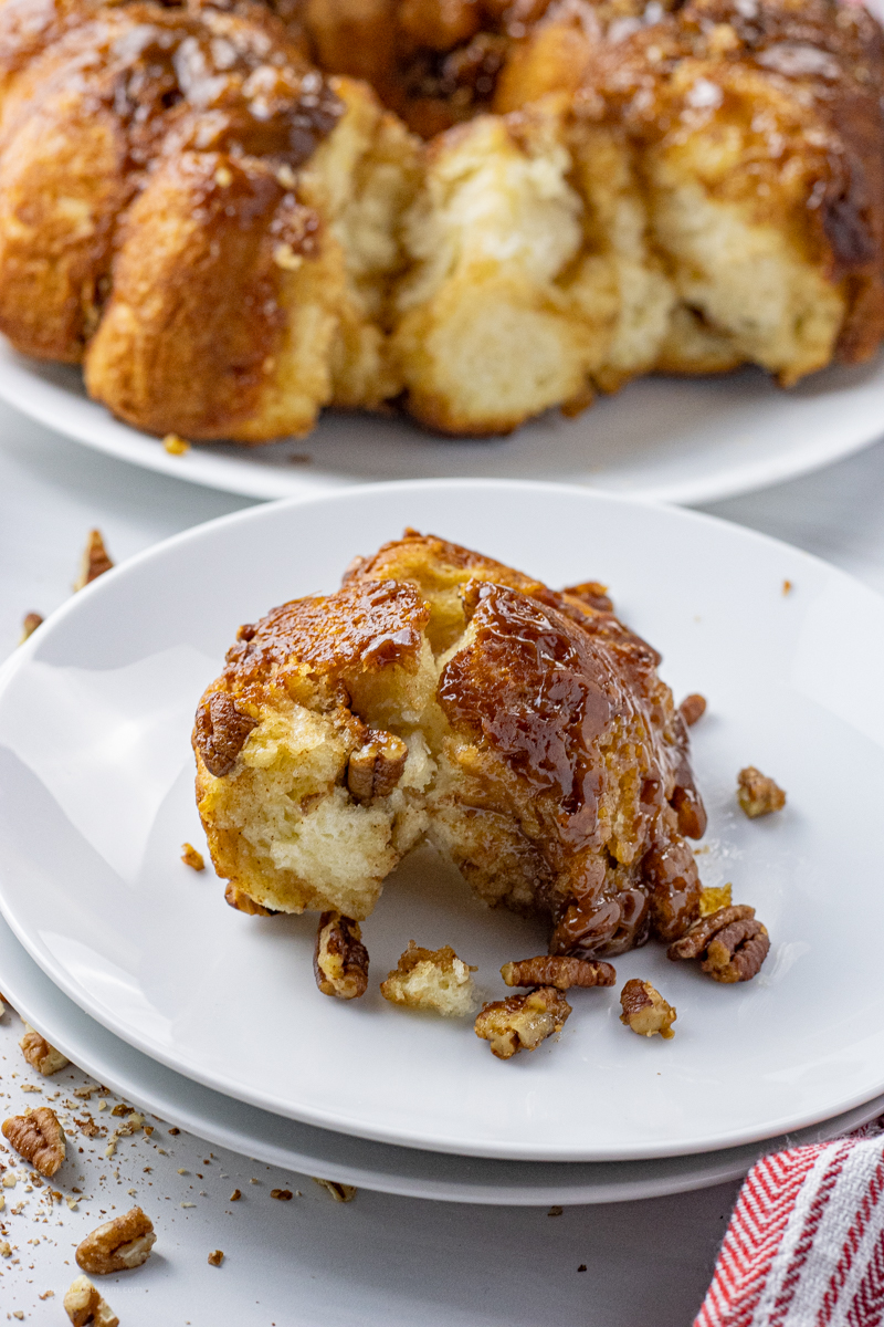 gooey caramel roll with pecans on a white plate