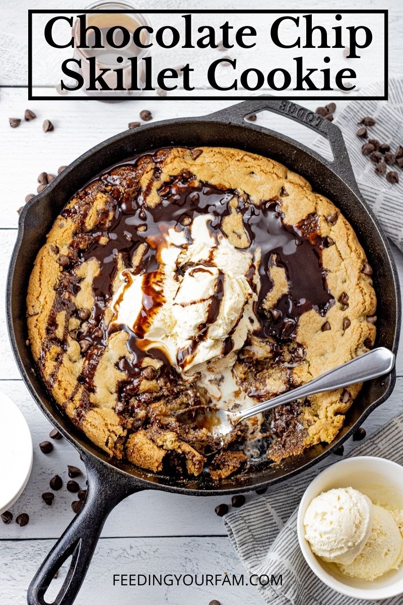 skillet chocolate chip cookie with topped with ice cream and chocolate sauce, with some spooned out