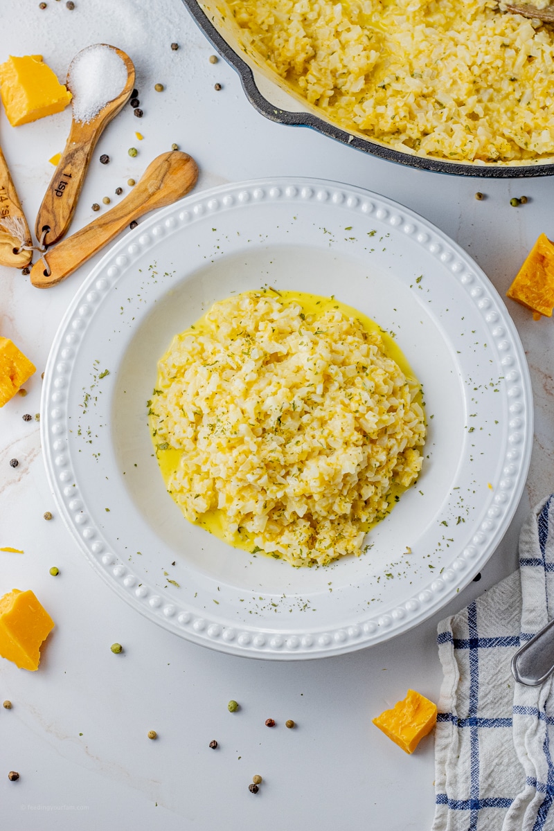 white bowl filled with cauliflower rice with cheese.