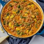 large skillet with a creamy tomato sauce with sausage and gnocchi