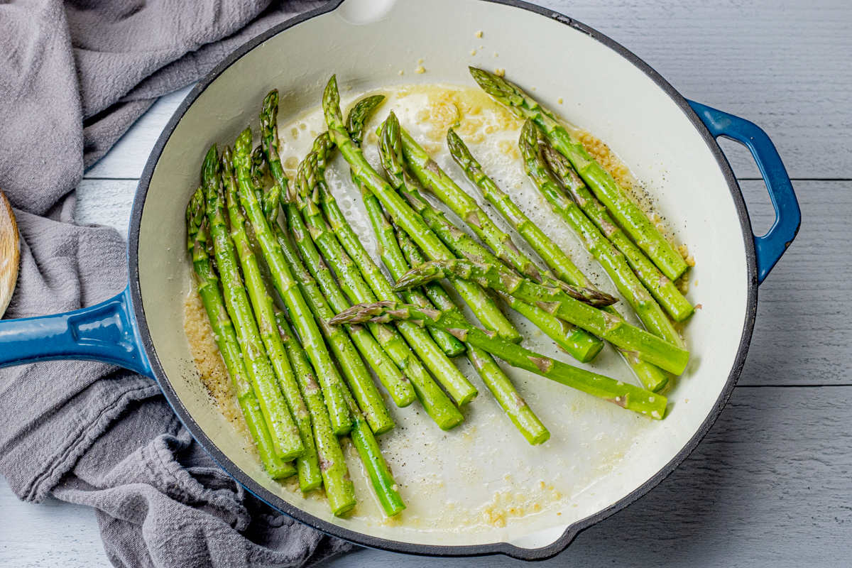 garlic spears cooked in butter and garlic in an enameled cast iron pan