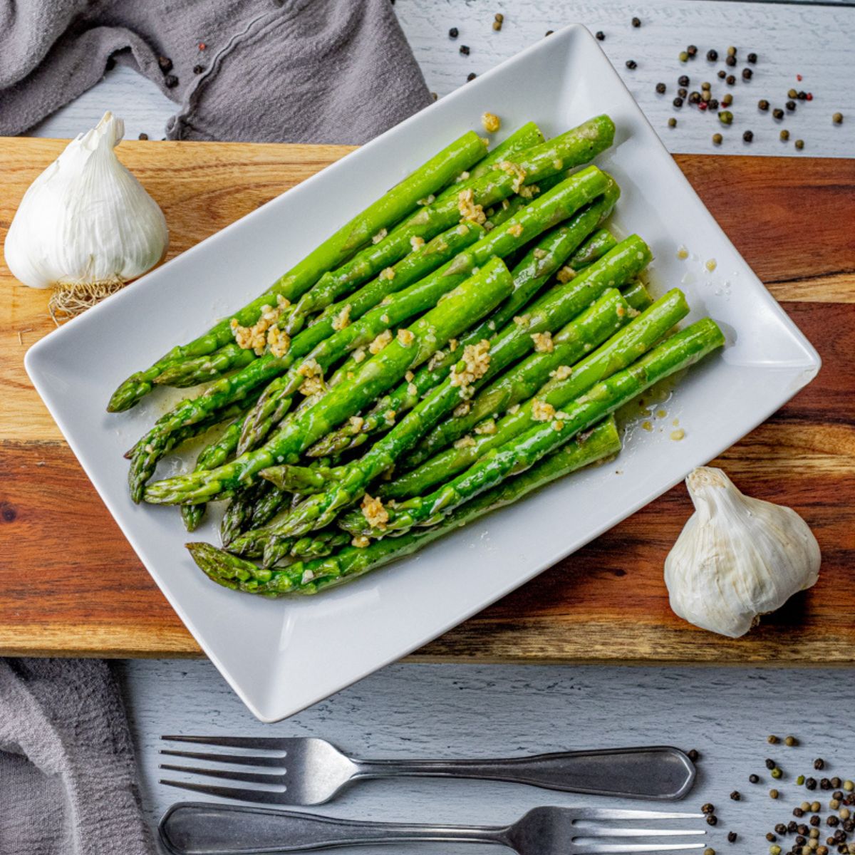 garlic butter asparagus on a white platter