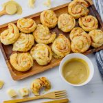 platter full of puff pastry ham and cheese swirls with honey mustard sauce