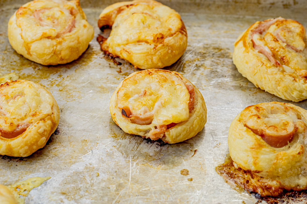 cooked ham and cheese pinwheel sandwiches cooked on a baking sheet