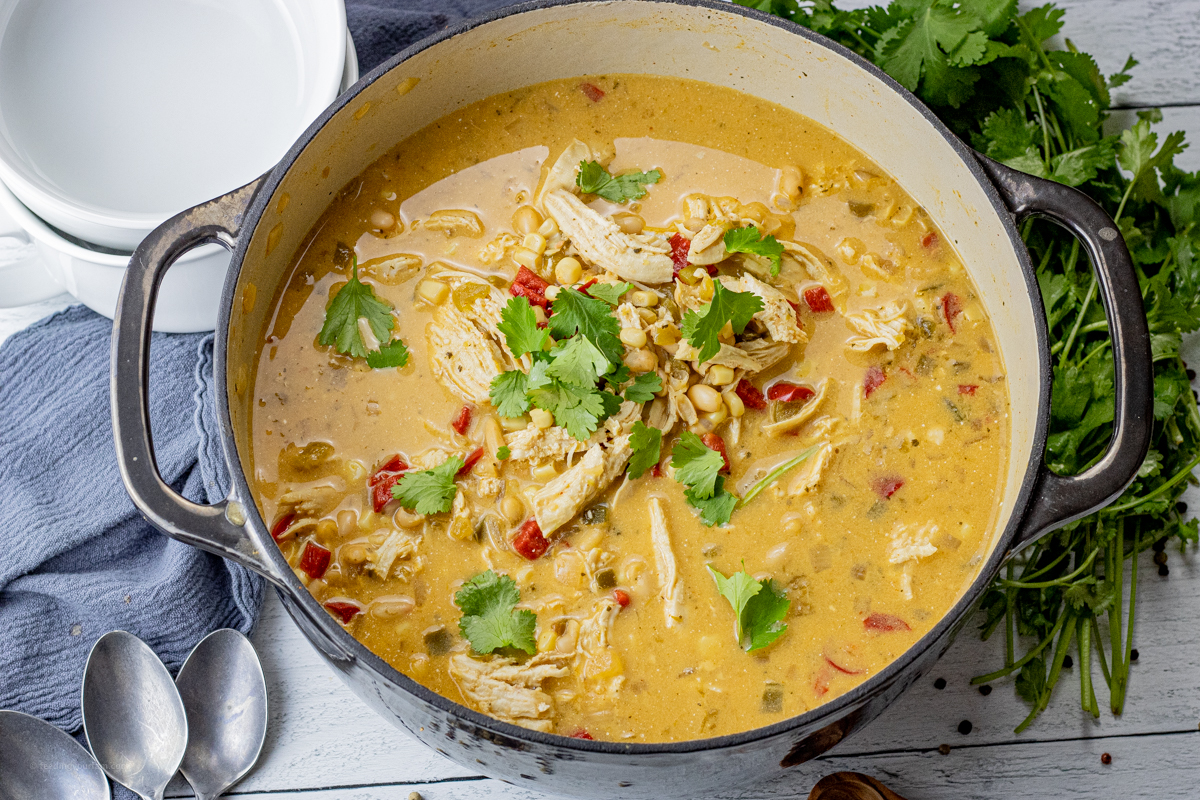 big black pot of white chili with chicken topped with cilantro
