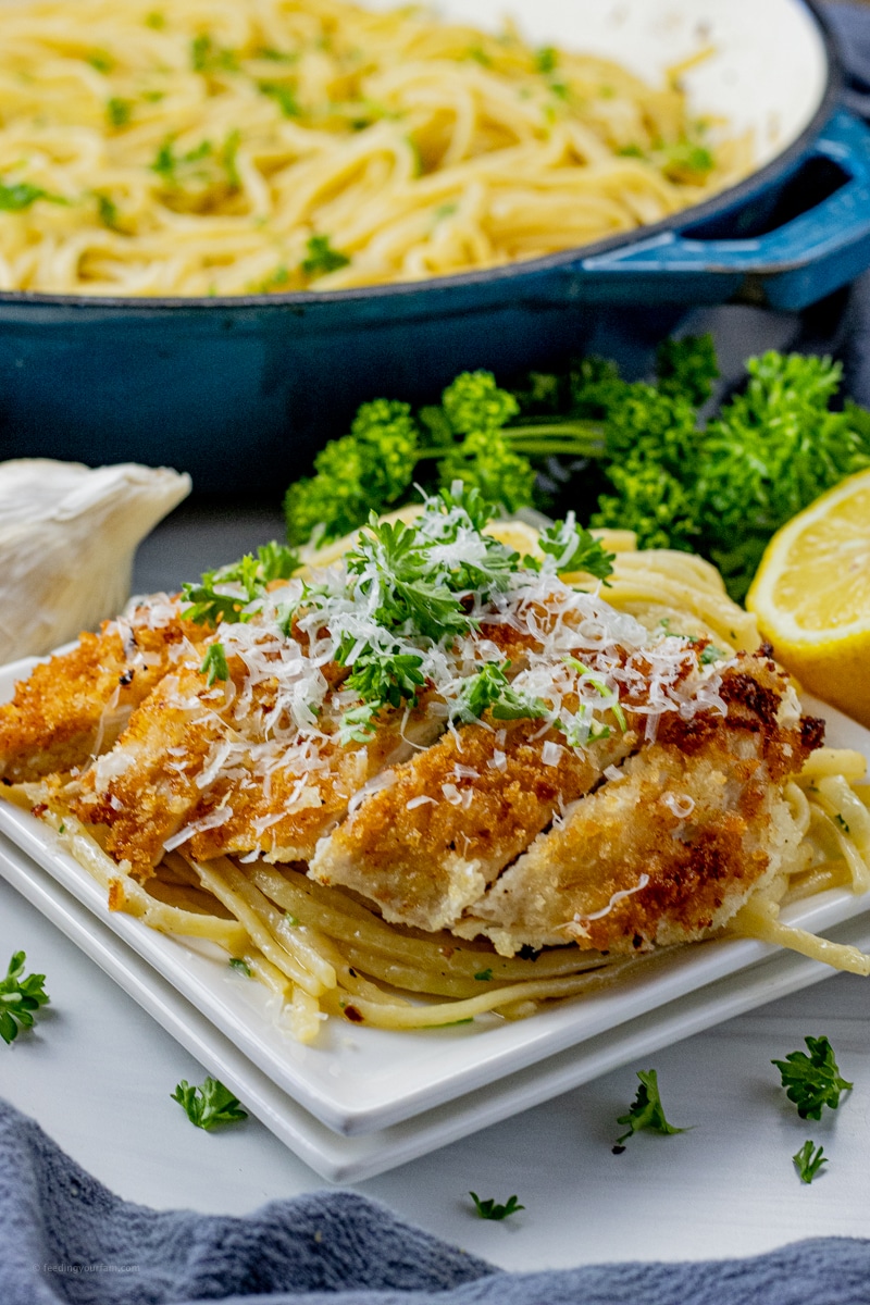 sliced, bread crumb coated chicken over pasta