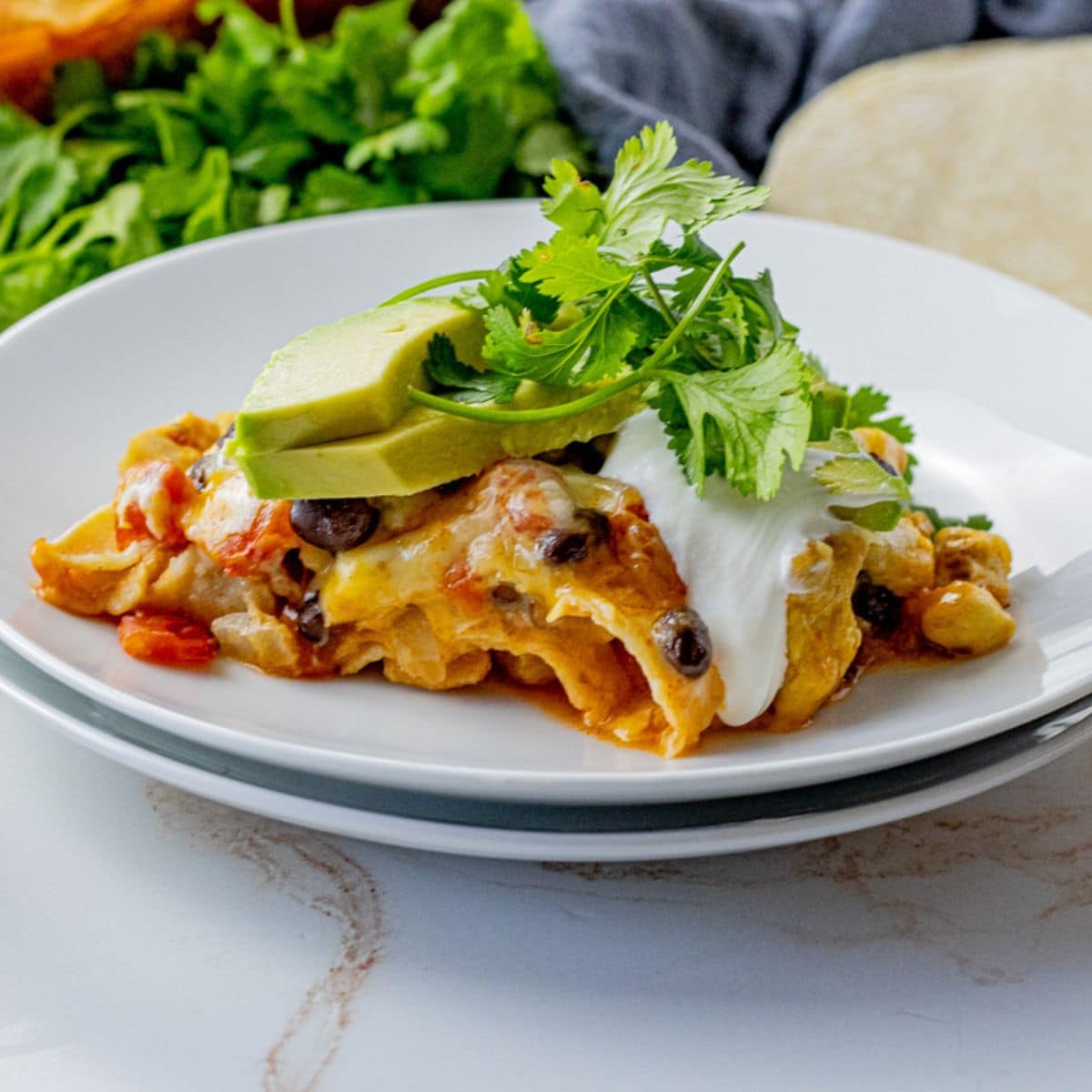 slice of layered tortilla casserole on a white plate