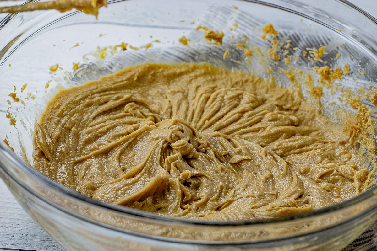 butter, sugars, eggs and vanilla mixed together in a large glass mixing bowl