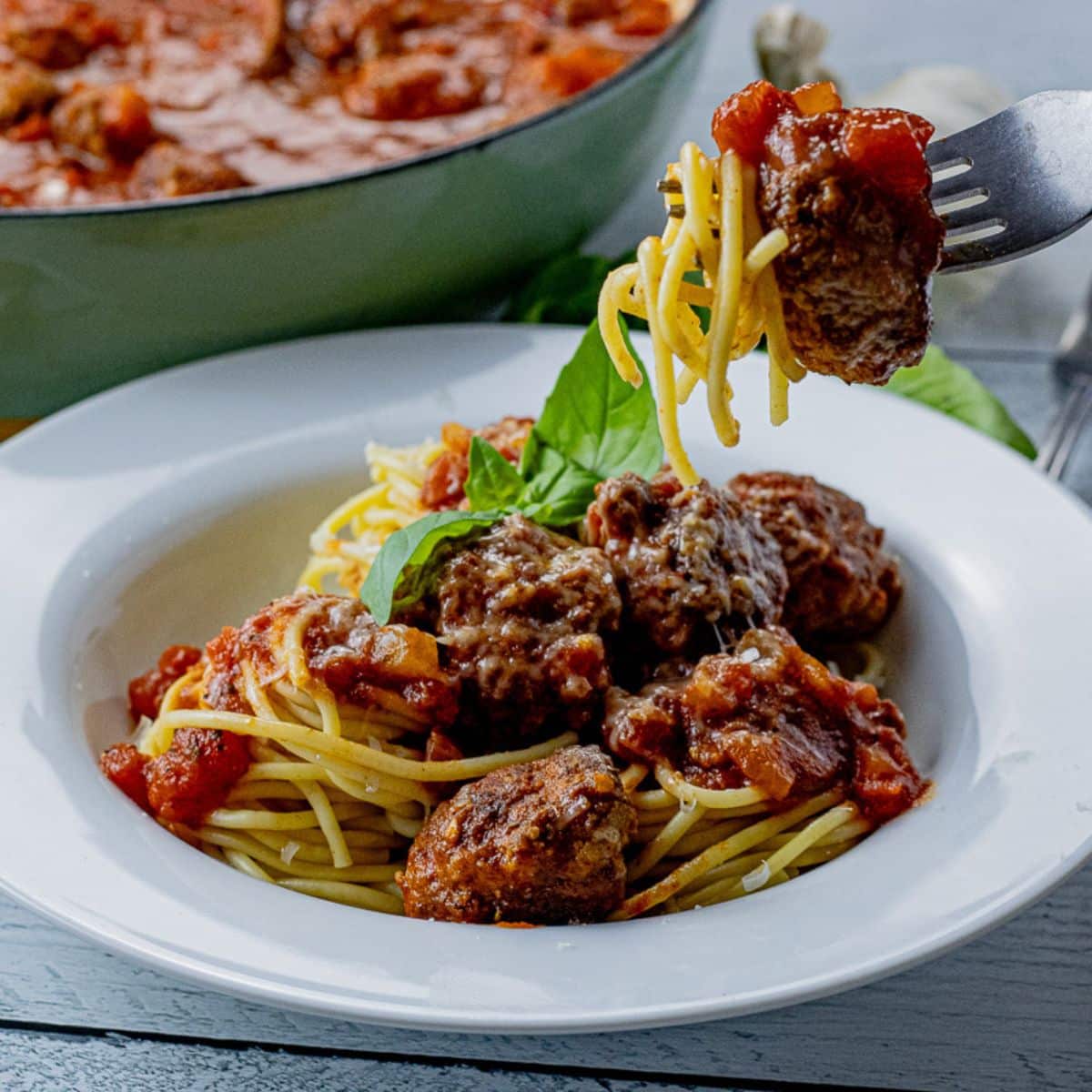fork lifting up a meatball with spaghetti