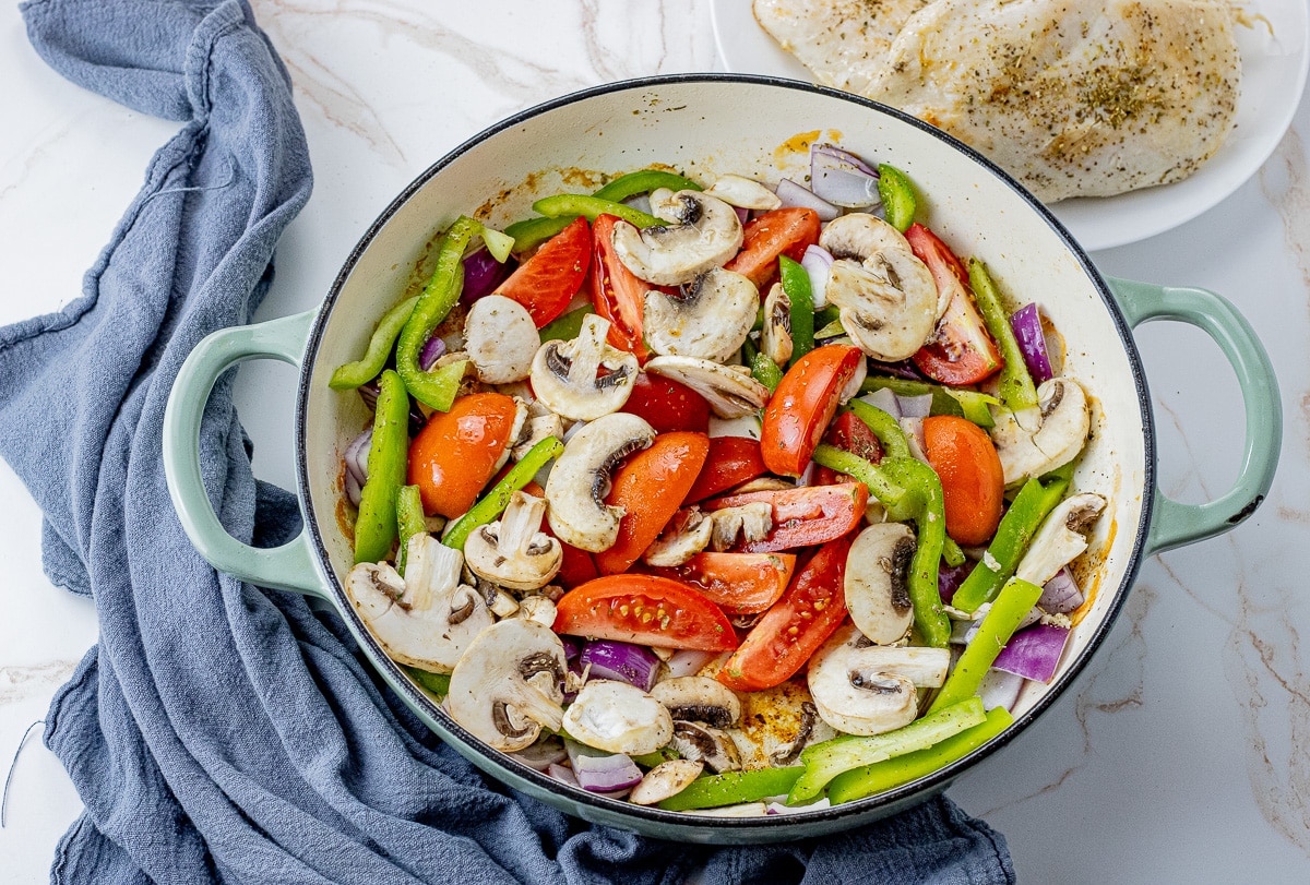 tomatoes, green peppers, mushrooms, red onions, garlic in a large cast iron pan