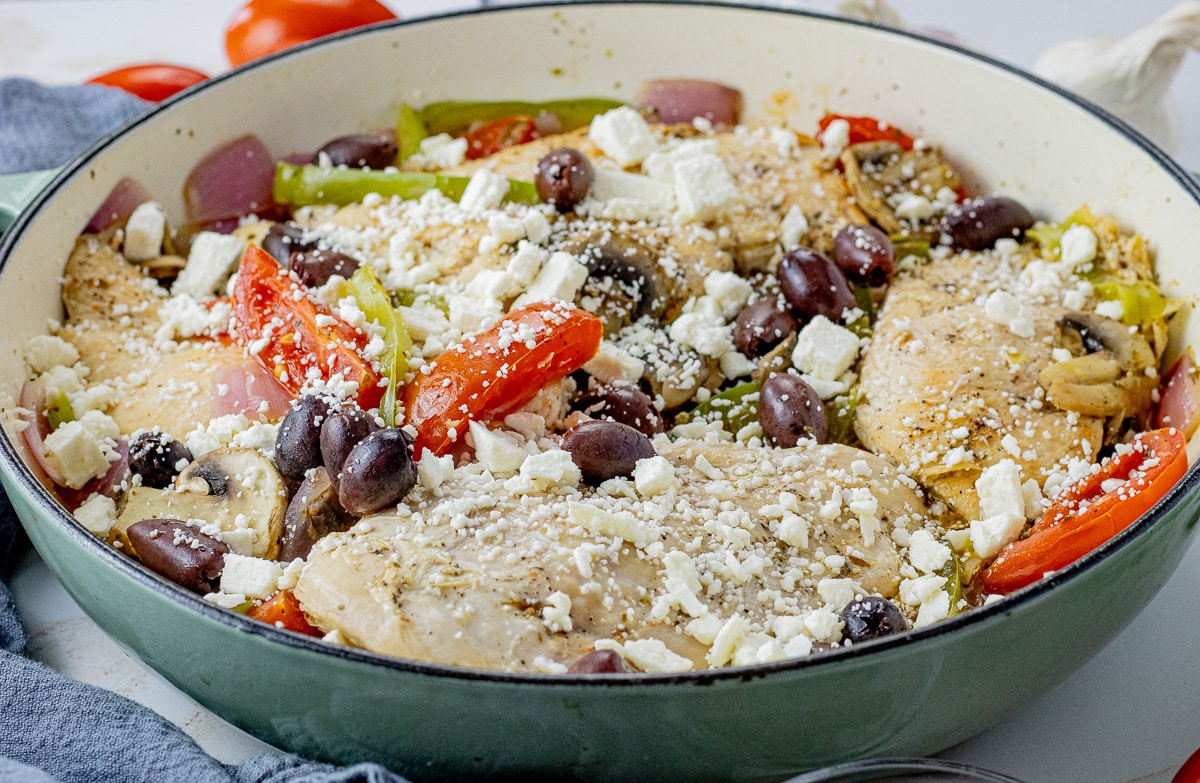 cast iron pan with chicken, tomatoes, green peppers, onions, green peppers, mushrooms, kalamata olives and feta cheese