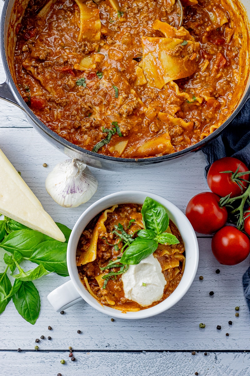 small bowl with lasagna soup topped with ricotta cheese and fresh basil
