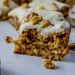 slice of walnut cake with vanilla frosting and chopped walnuts on top