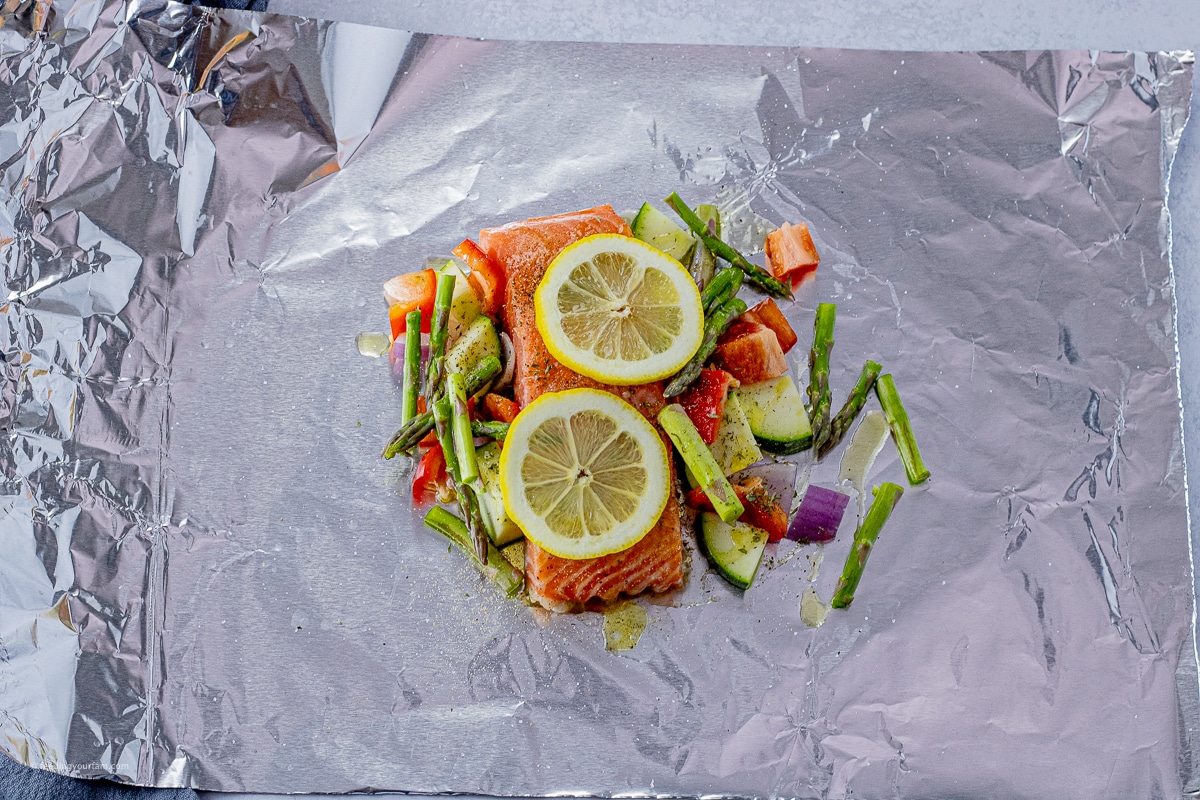 uncooked salmon with vegetables on a sheet of foil