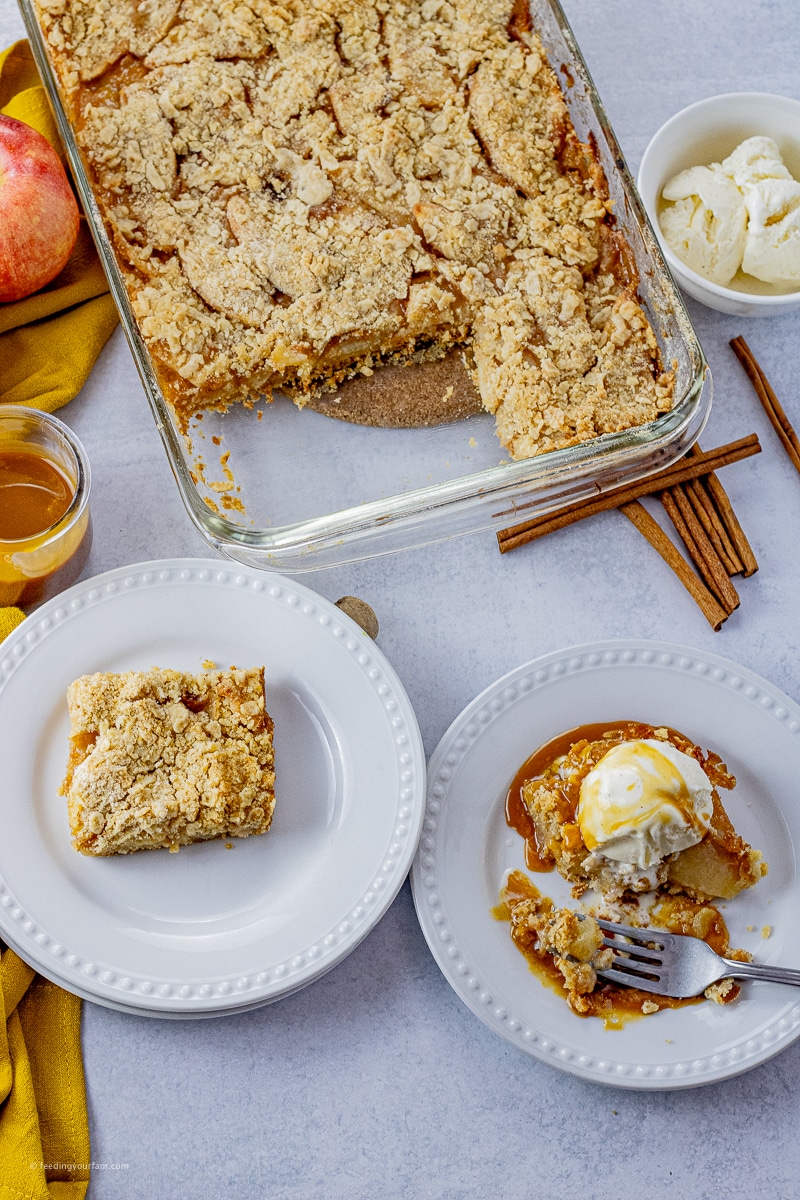 cooked apple pie bars sliced into squares and topped with ice cream