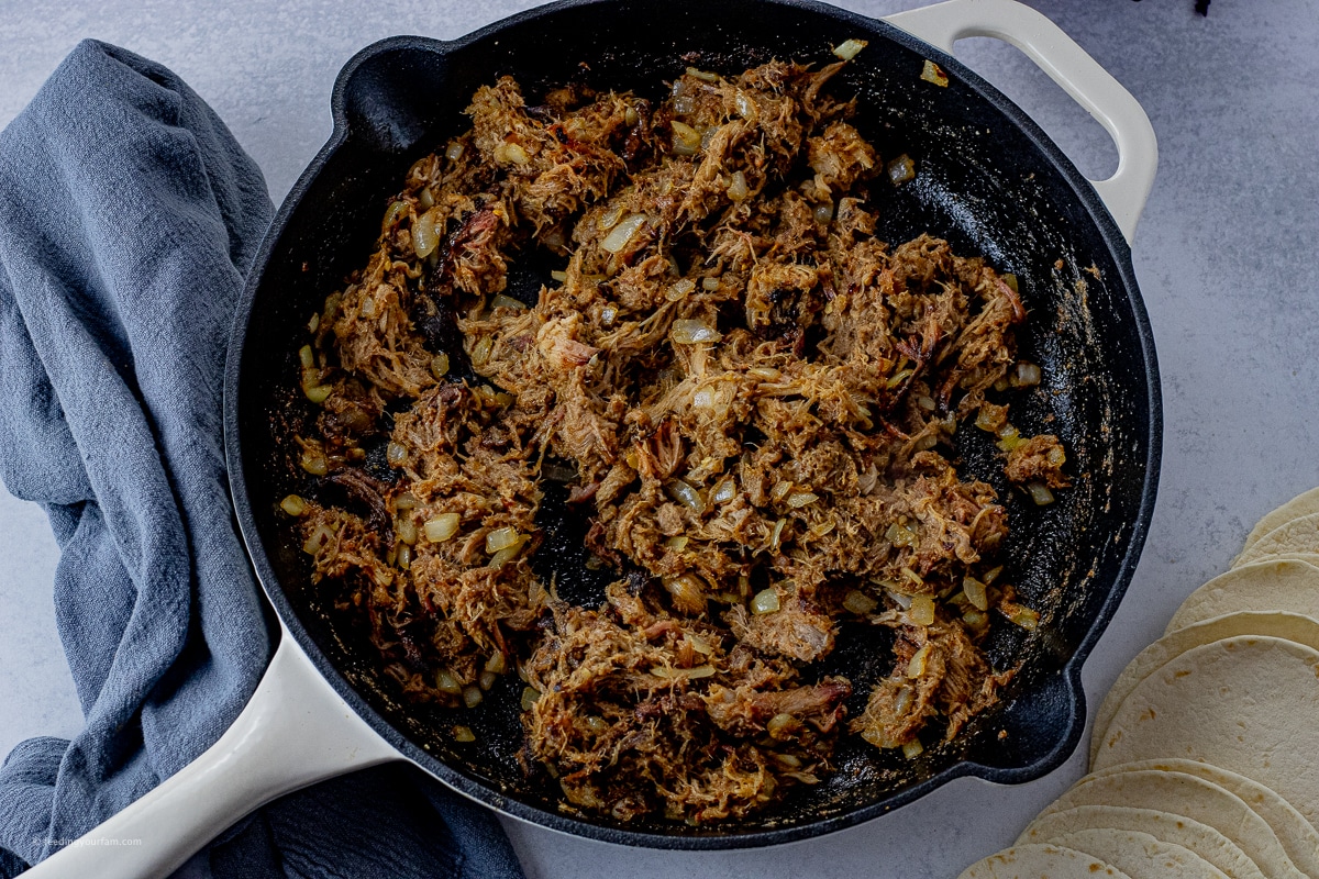 easy pulled pork tacos pulled pork taco meat in a cast iron pan