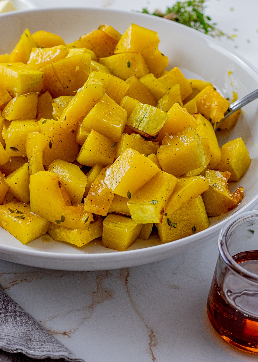 butternut squash cubes cooked and in a white bowl