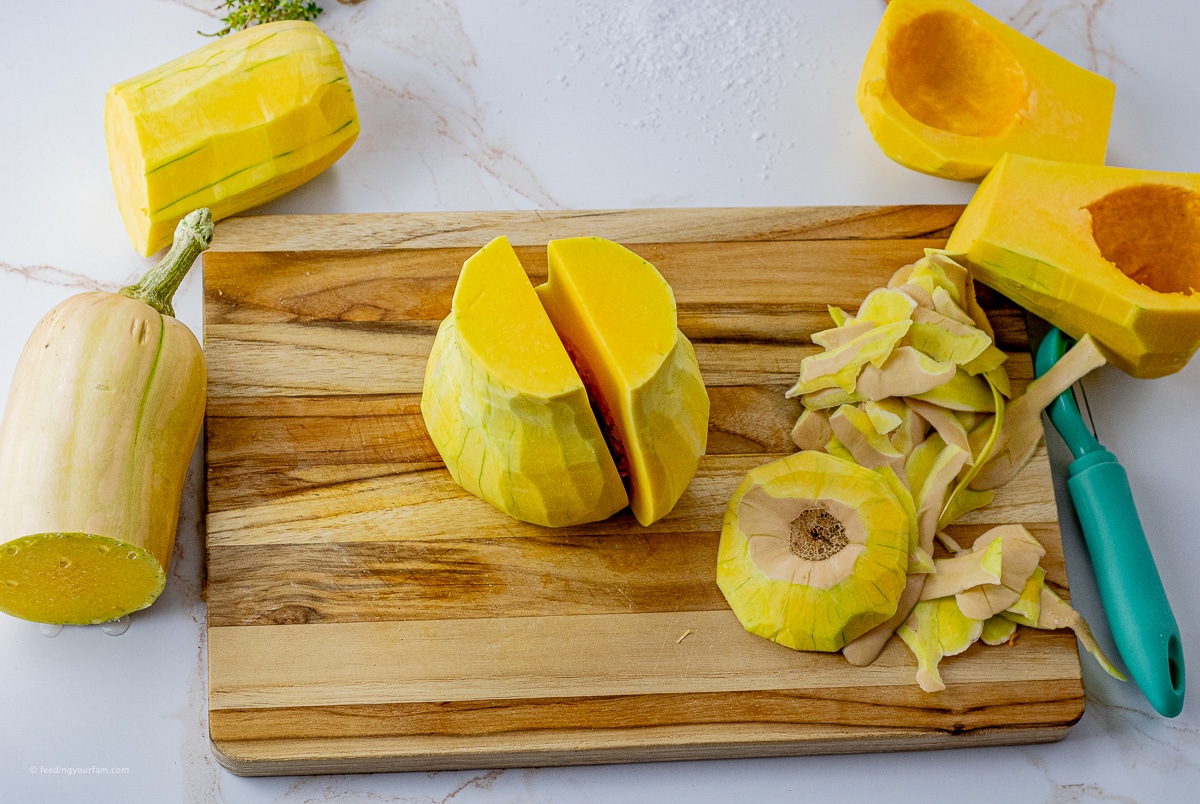 peeled butternut squash on a wooden cutting board that has been peeled and sliced in half
