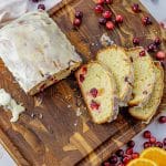 sliced cranberry orange bread on a wooden cutting board