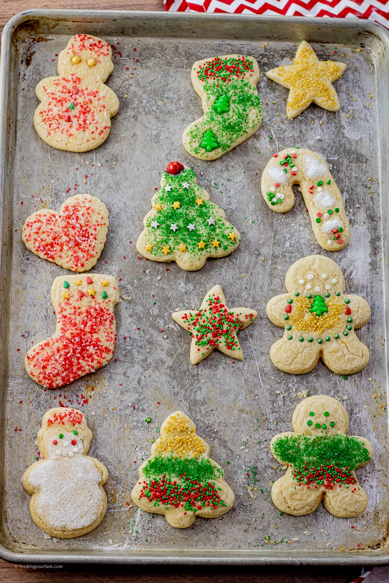 cooked cut out Christmas cookies covered with sprinkles on a baking sheet