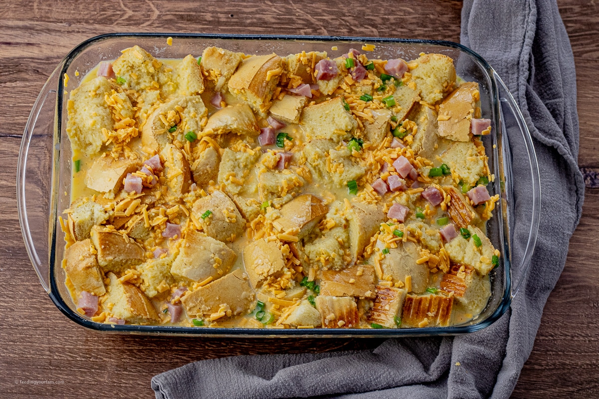 uncooked breakfast casserole made with bread, ham, cheese and eggs