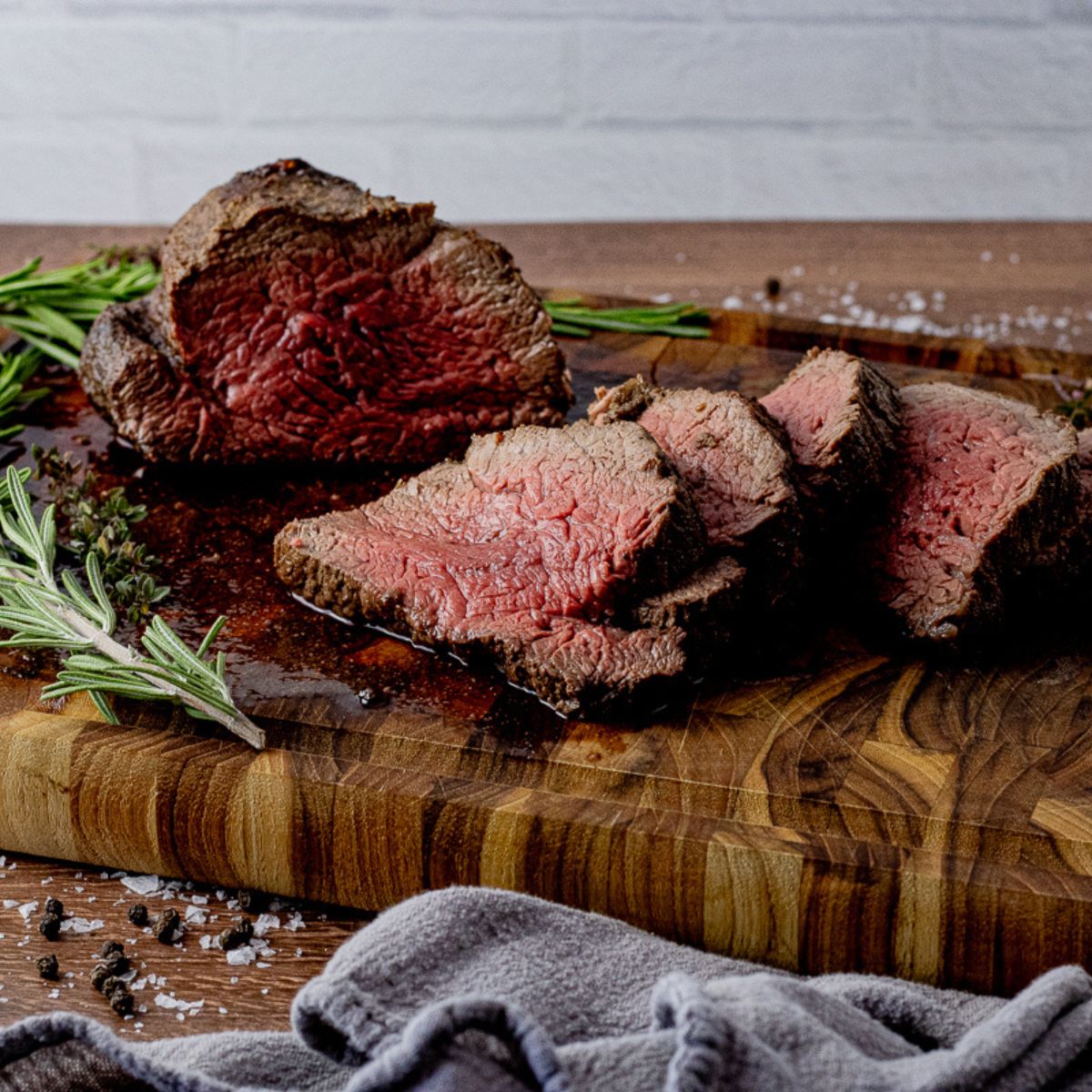 sliced beef tenderloin on a wooden cutting board