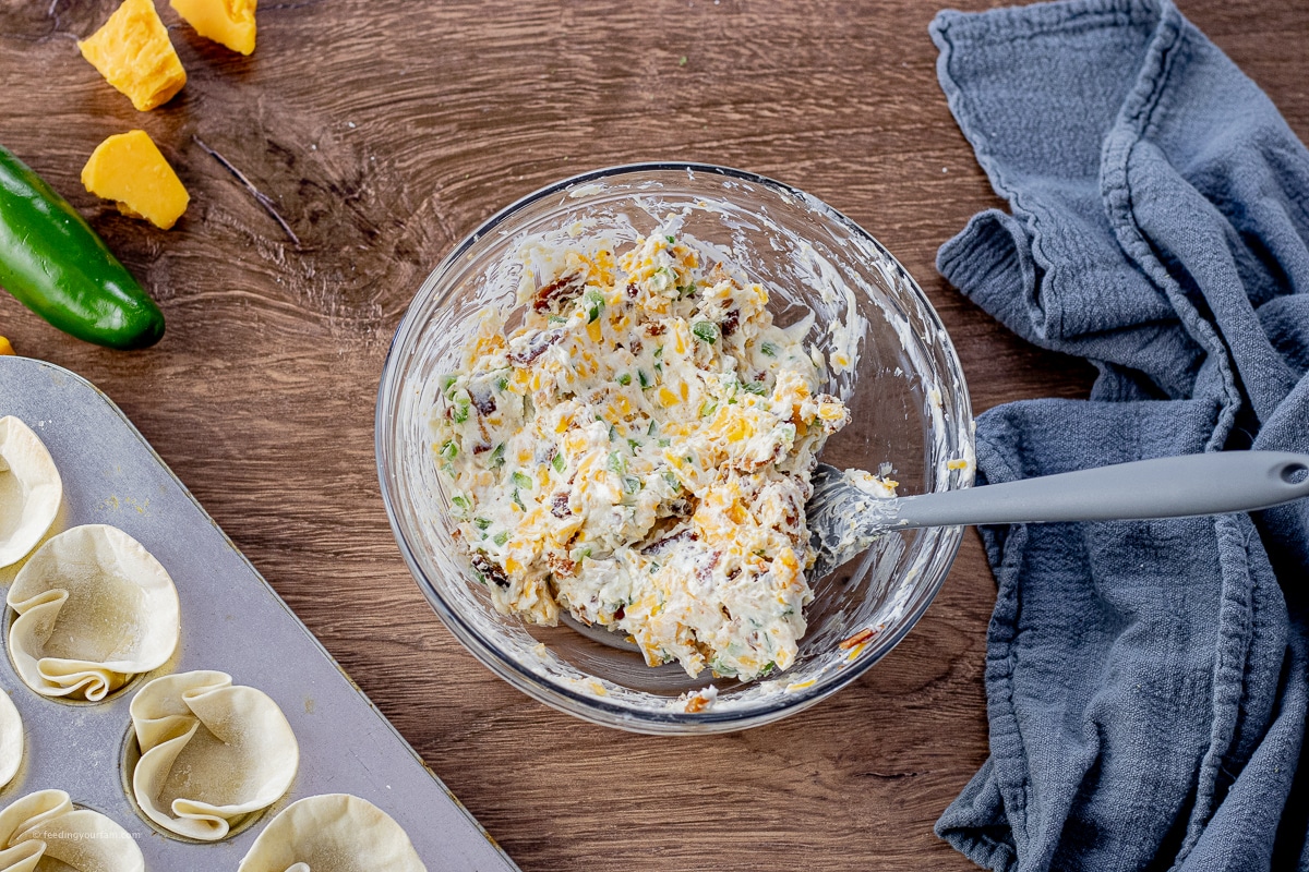 bowl with mixed jalapeno popper mixture with cream cheese and shredded cheddar