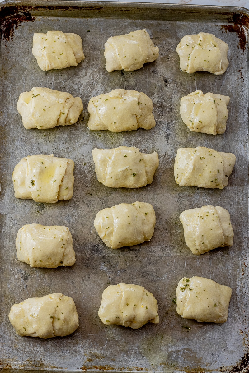 crescent rolls stuffed with chicken and rolled up and topped with butter