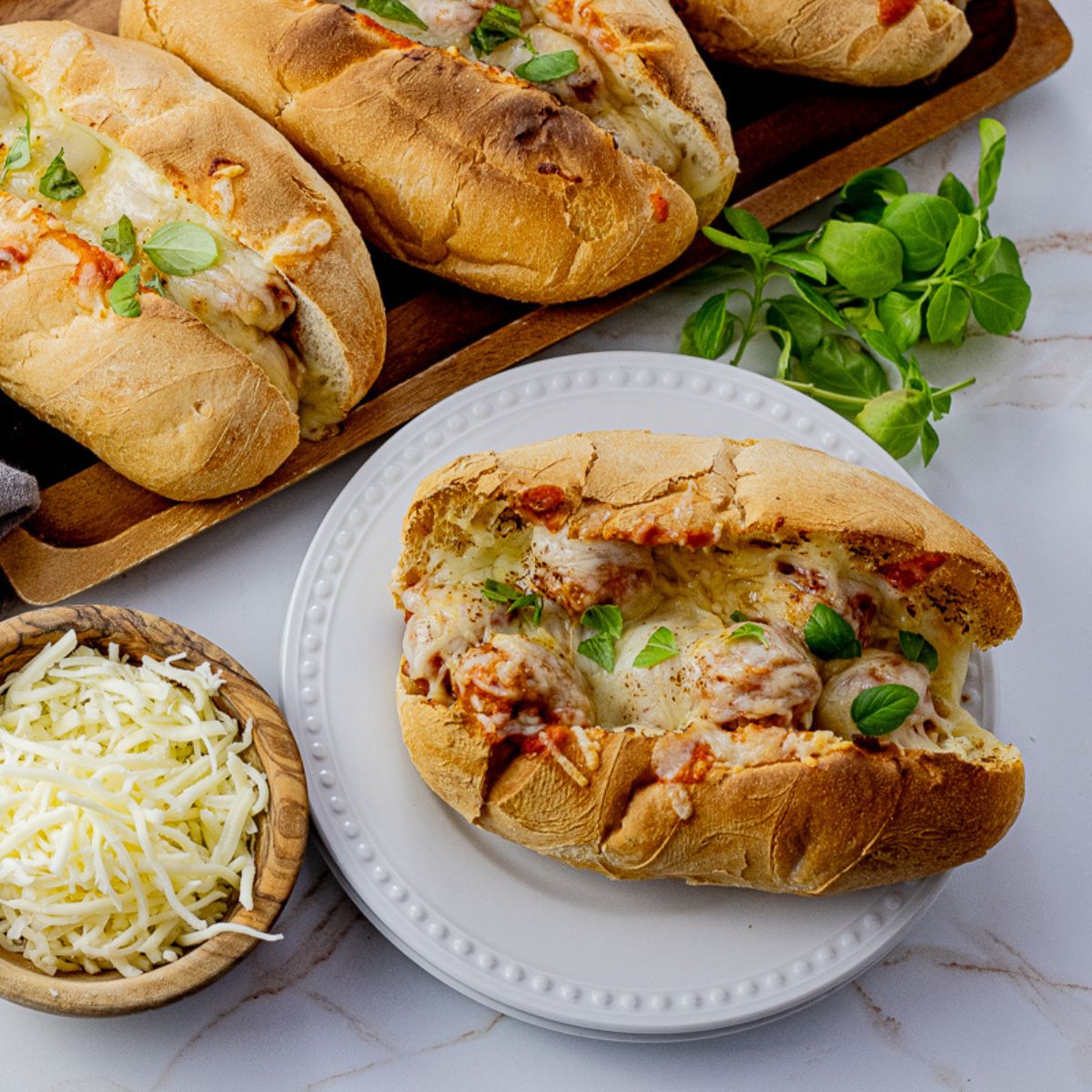 meatball sandwiches in sliced hoagie buns topped with melted cheese