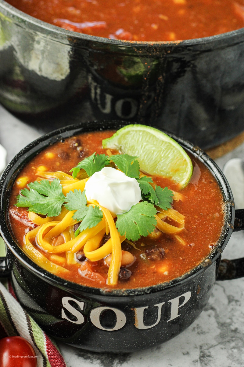 taco soup topped with sour cream, cheese and cilantro. 8 can taco soup recipe made with just cans of food