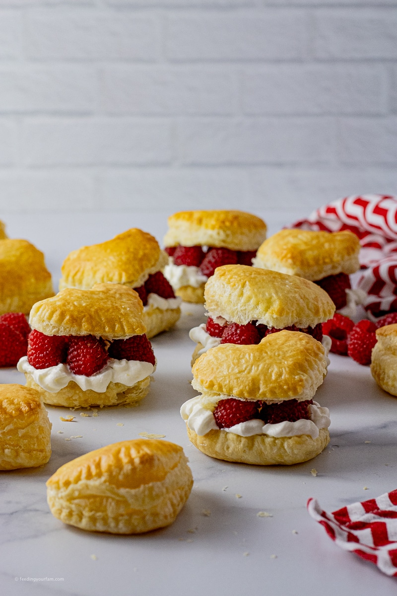 heart shaped puff pastry filled with whipped cream and raspberries