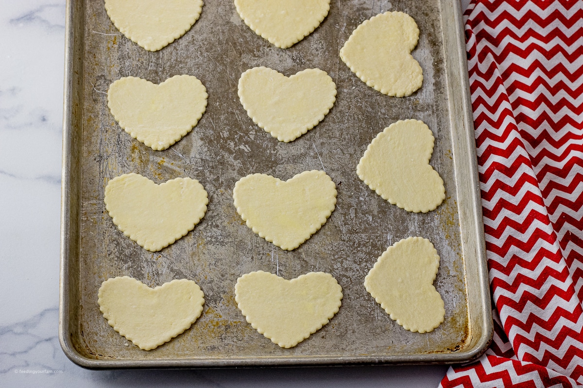 cut out pastry sheets into heart shapes on a baking sheet