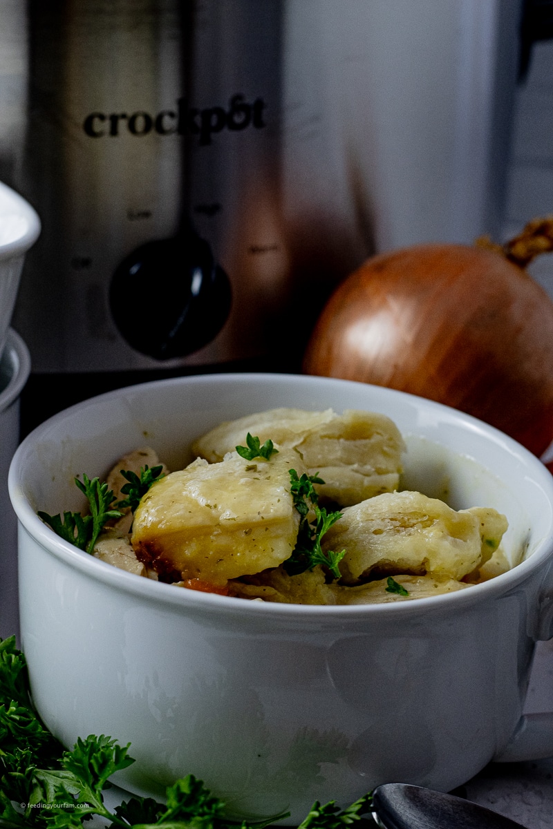 canned biscuits on top of chicken soup in a white soup bowl