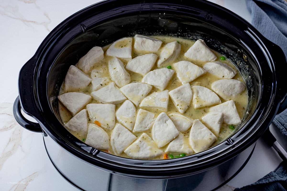 canned biscuits on top of chicken soup in a slow cooker