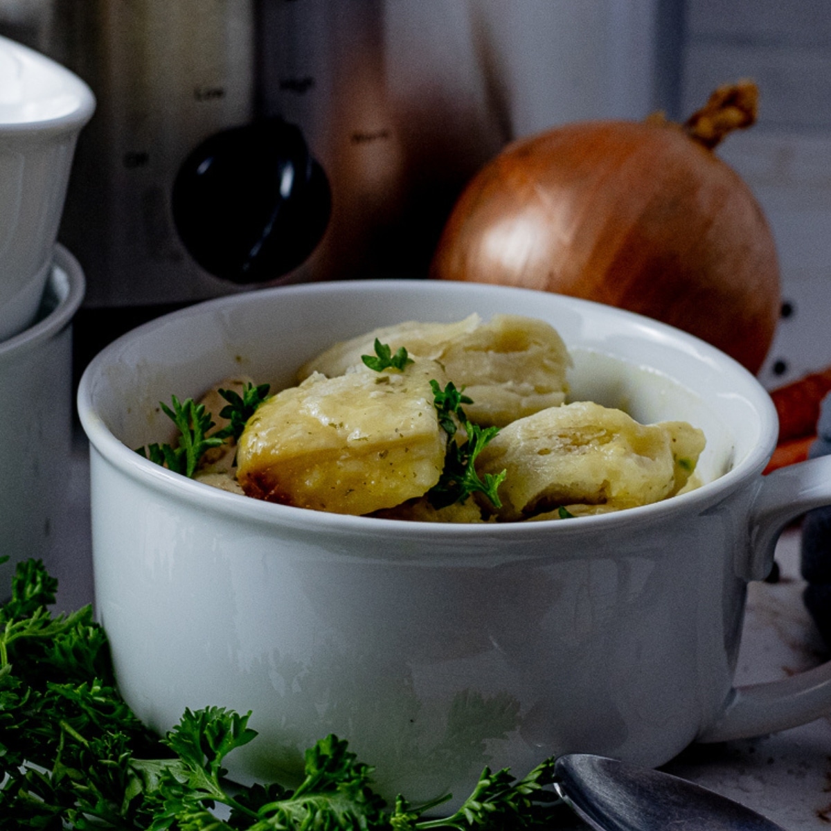 white bowl filled with chicken and dumplings soup