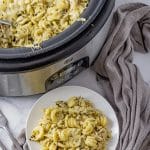 twisted pasta in a pesto sauce with shredded chicken and melted mozzarella